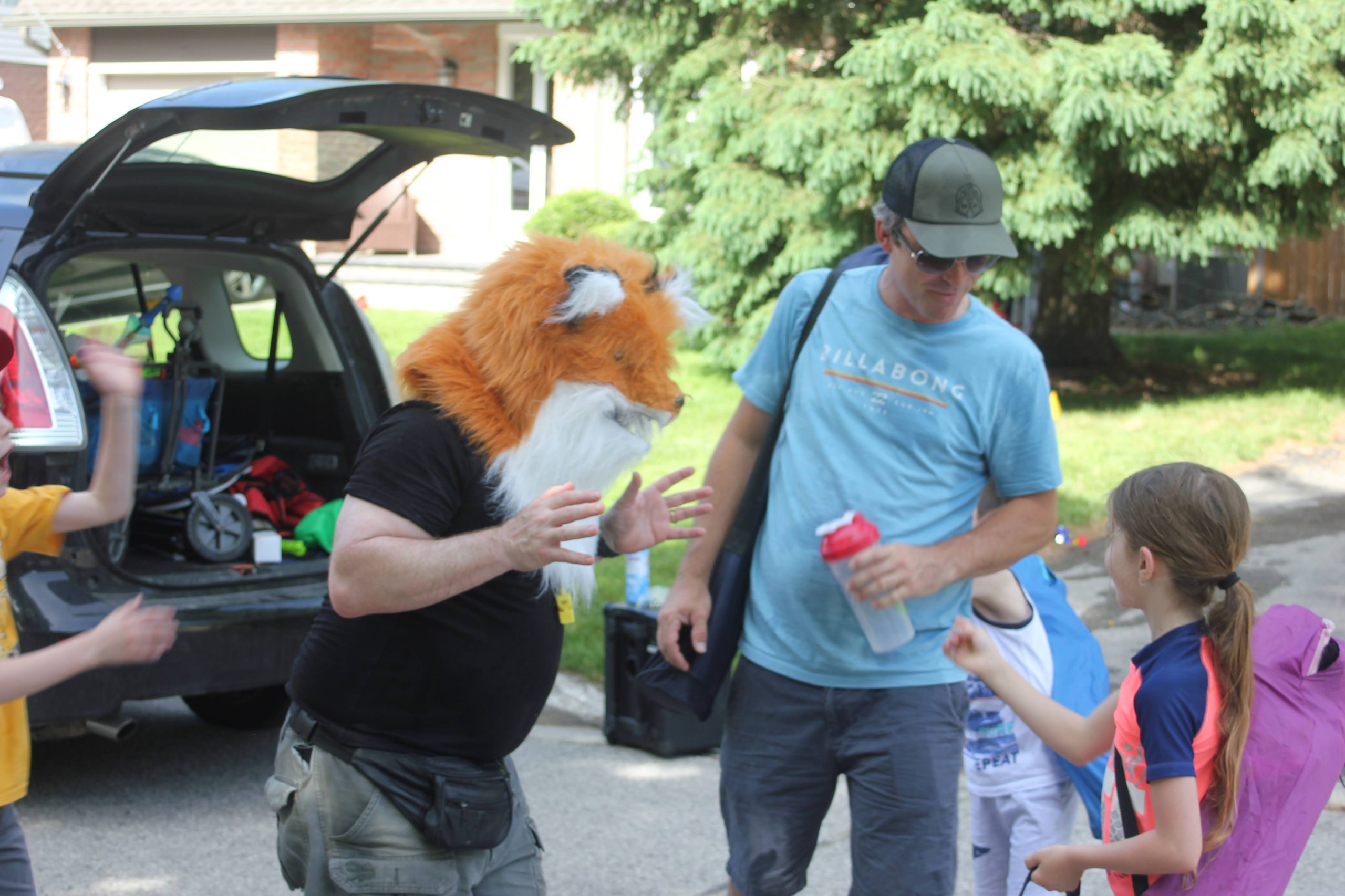 Coach Steve playfully wears an animal mask at a kids party